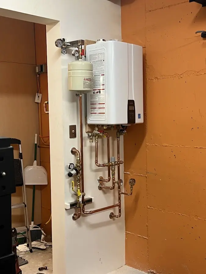 Plumbing technician inspecting water heater connections in Lake Land'Or